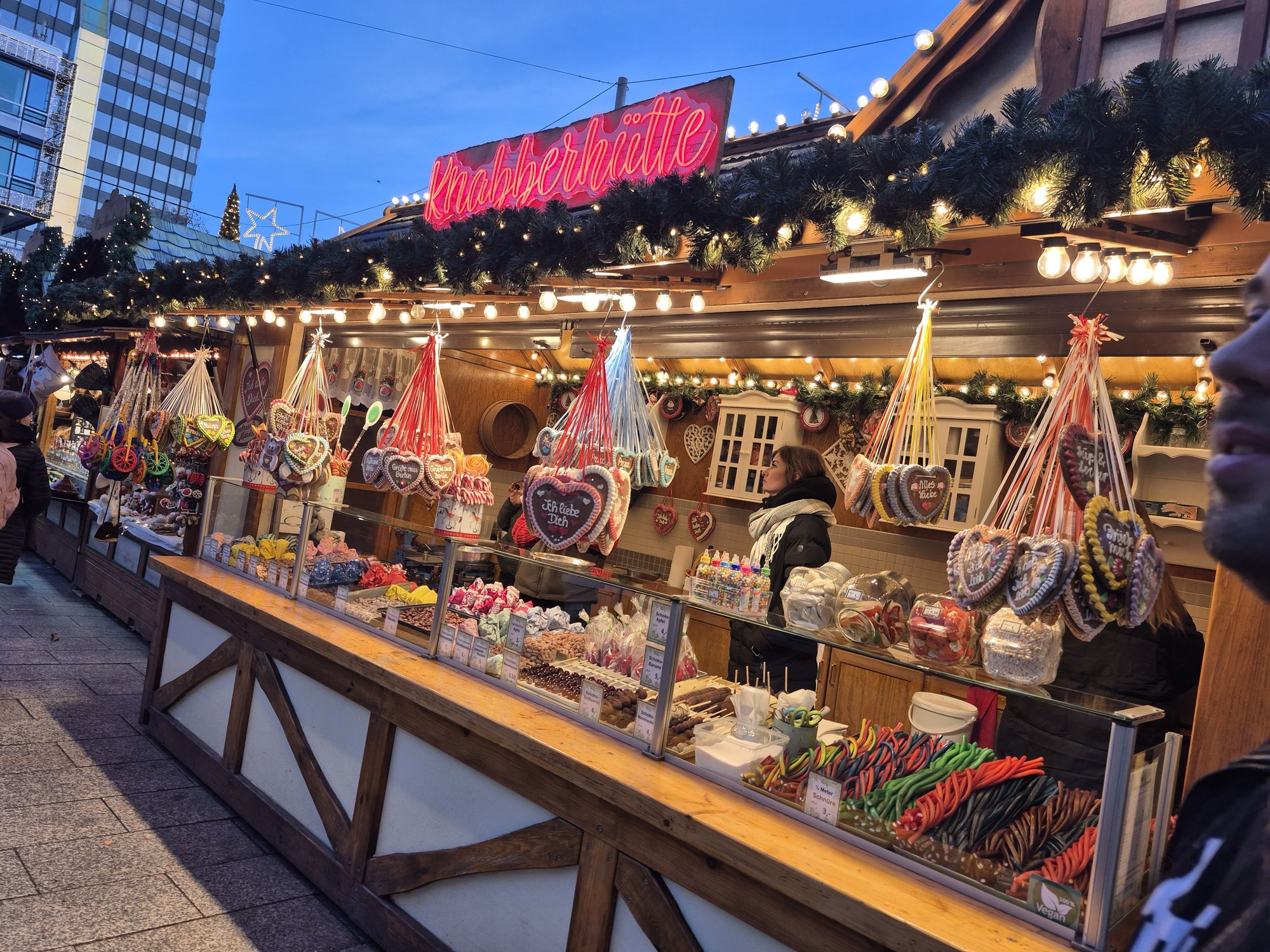 Wooden stalls strung with lights at the Christmas market on Breitscheidplatz, next to the Kaiser Wilhelm Memorial Church, in the December afternoon